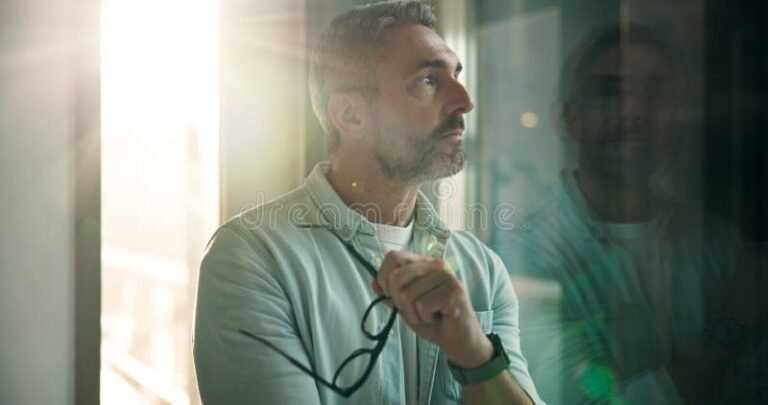 henkilo miettii tyopaikan ikkunassa