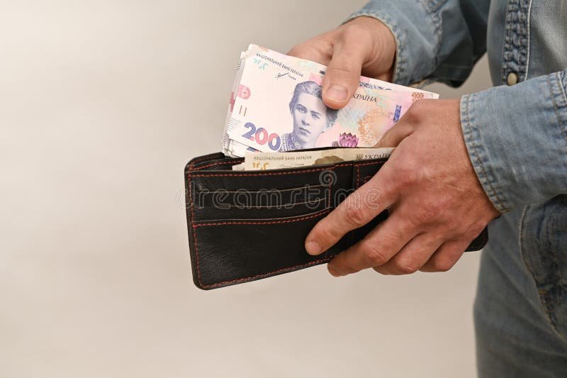 henkilo tarkastelee lompakkoa tai laskuja